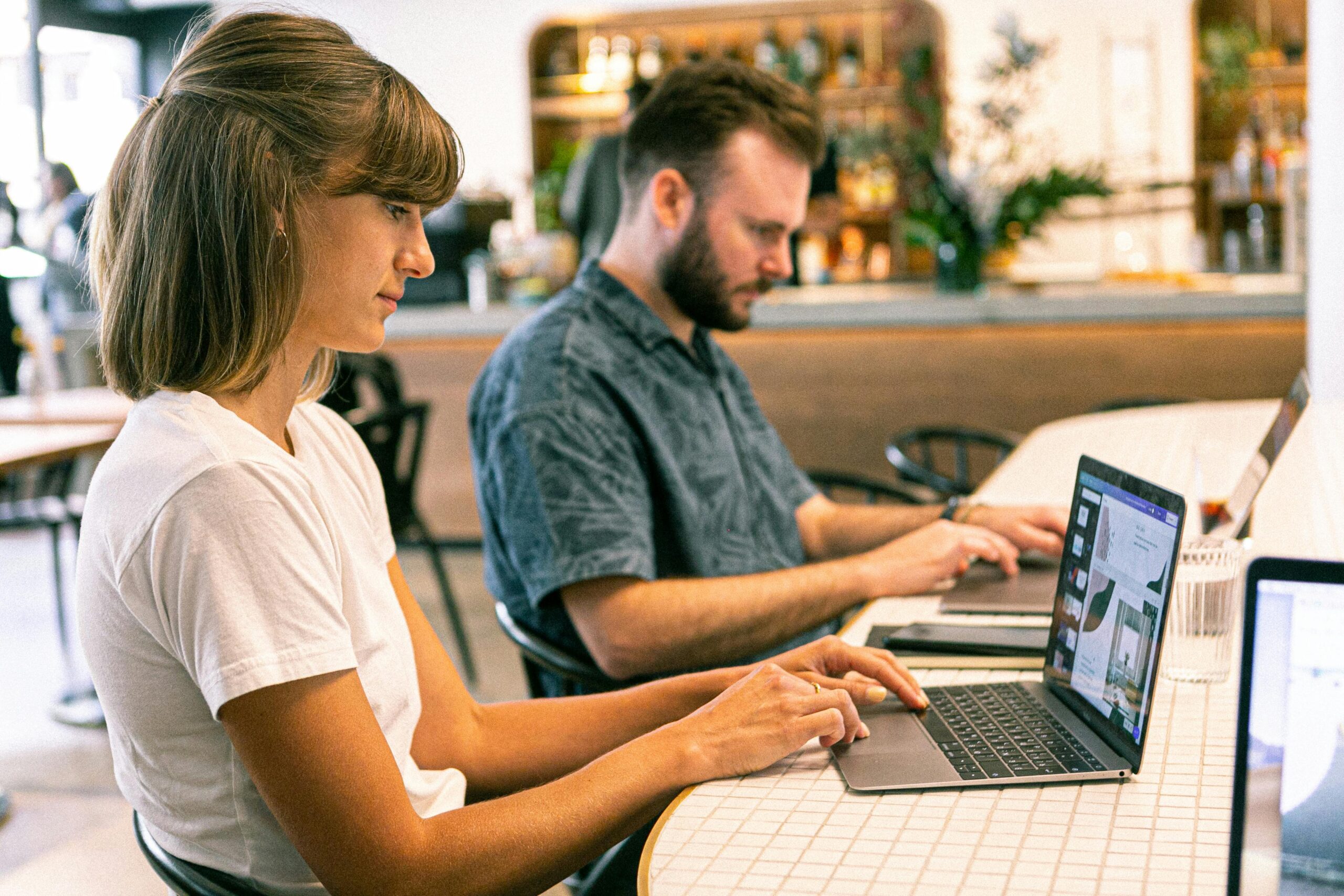 A business professional at a desk, mapping out an automated digital ecosystem on a laptop with a CRM dashboard visible.